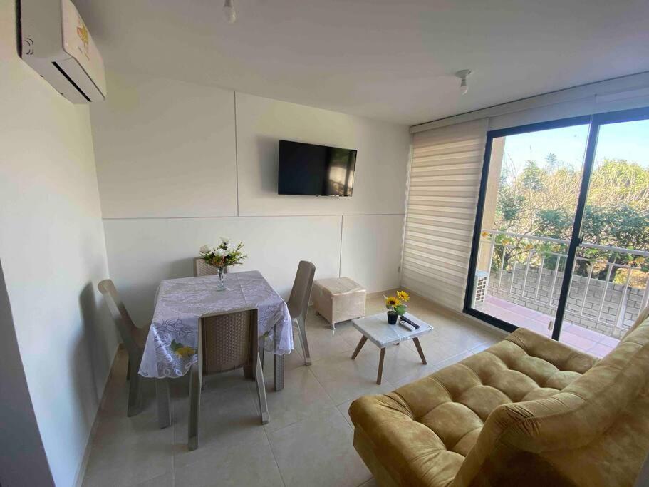 uma sala de estar com uma mesa e um sofá em Hermoso apartamento con vista a la Sierra em Santa Marta