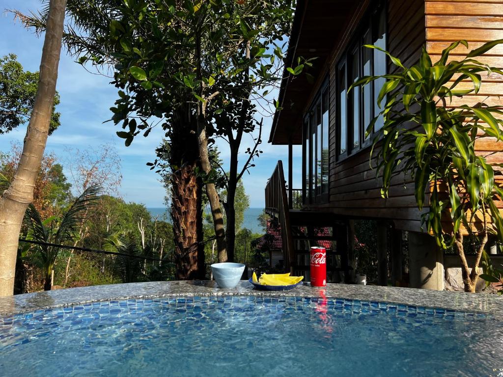 ein Pool neben einem Haus mit einem Baum in der Unterkunft Ong Huong House Can 2 in Phu Quoc