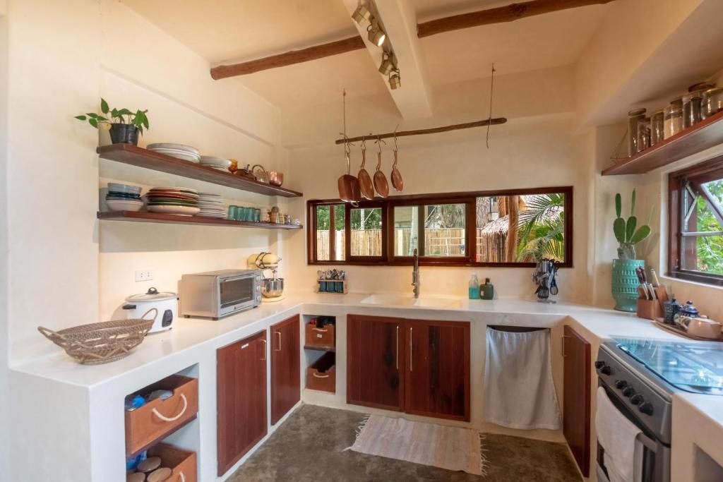eine Küche mit weißen Arbeitsflächen und Holzschränken in der Unterkunft Vedya Boutique Hostel in General Luna