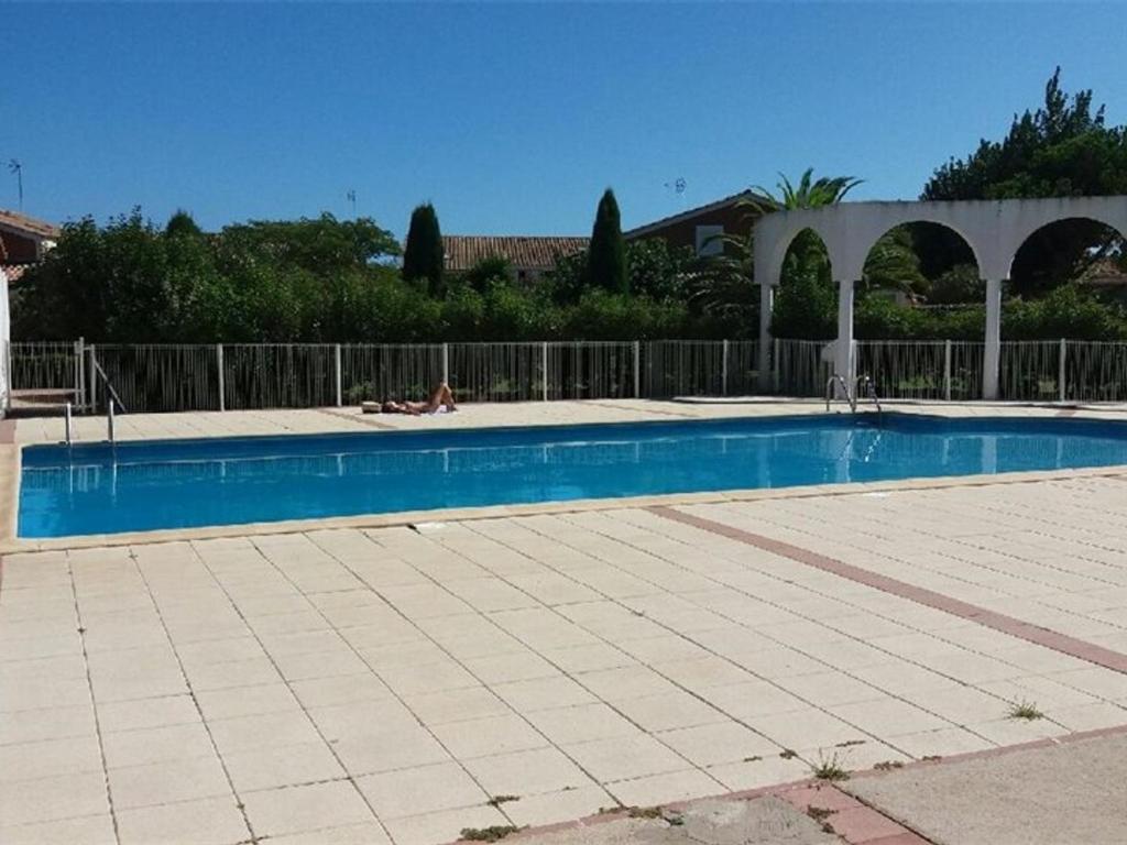 uma grande piscina com uma cerca em redor em Maison Vendres, 2 pièces, 4 personnes - FR-1-701-41 em Vendres