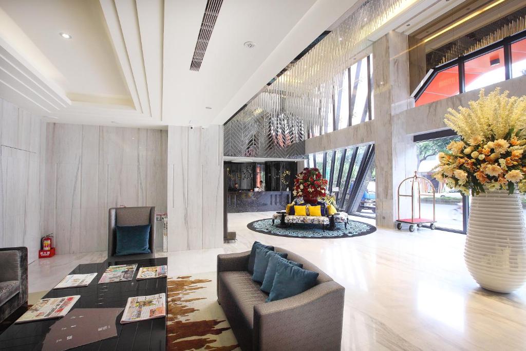 a lobby with a couch and a vase of flowers at 冠月精品旅館-Puli Ease Hotel in Puli