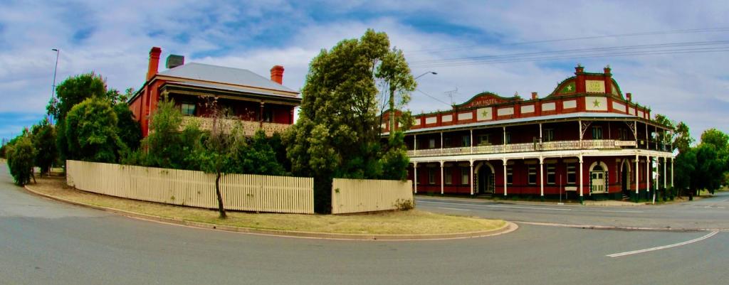 um edifício vermelho e branco na esquina de uma rua em HISTORIC STAR LODGE and STATION MASTERS HOUSE NARRANDERA em Narrandera