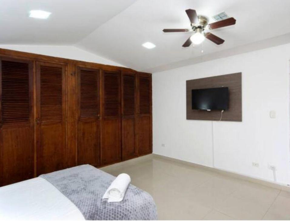 a bedroom with a ceiling fan and a tv at NAMASTE ELEAN 2A in Cali