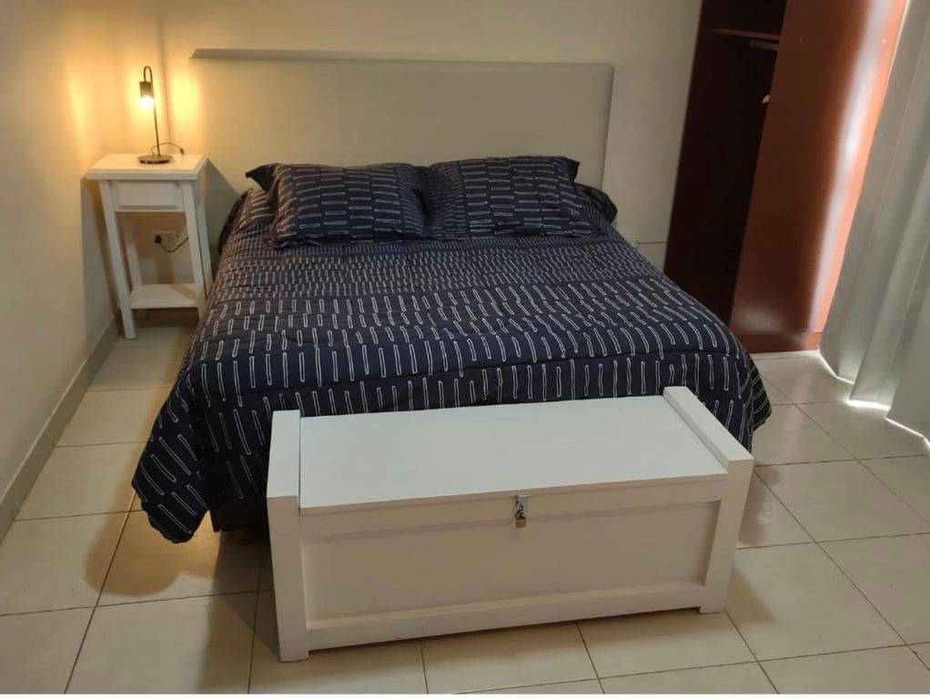1 dormitorio con 1 cama con un cajón blanco y una mesa en Coihue monoambiente en San Carlos de Bariloche