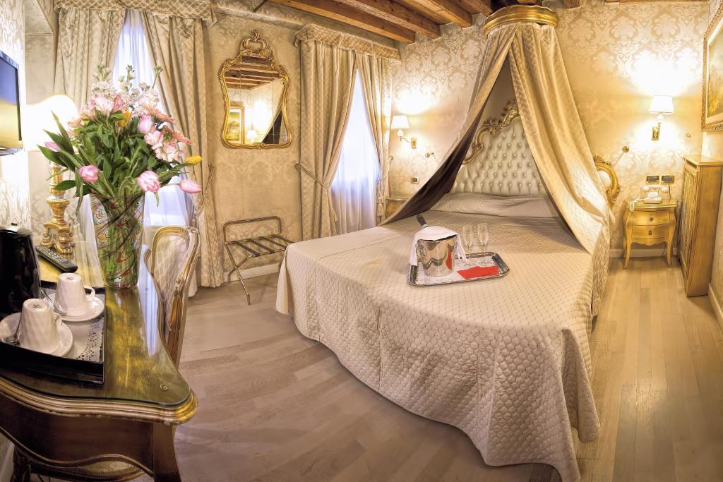 
a hotel room with a large bed and a large window at Hotel Noemi in Venice
