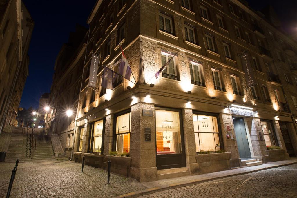 圣马洛Hôtel des Marins, Saint-Malo的夜晚街道上亮着灯的建筑