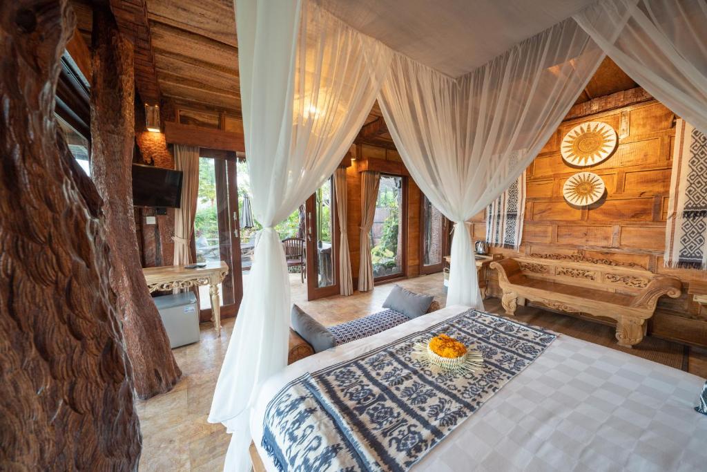 a bedroom with a bed in a log cabin at Villa Lignea in Tegalalang
