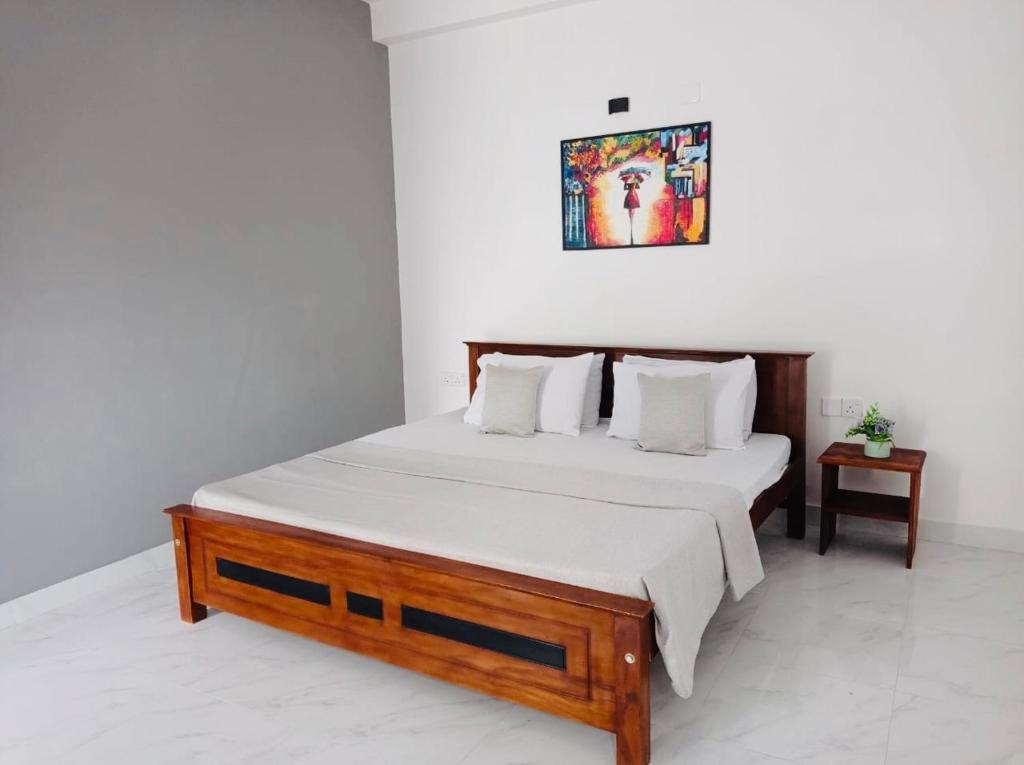 a bedroom with a large bed with white sheets at kandy hill vilaa in Kandy