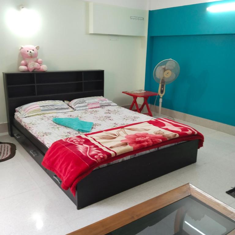 a bedroom with a bed with a teddy bear on it at Deep Home stay in Agartala