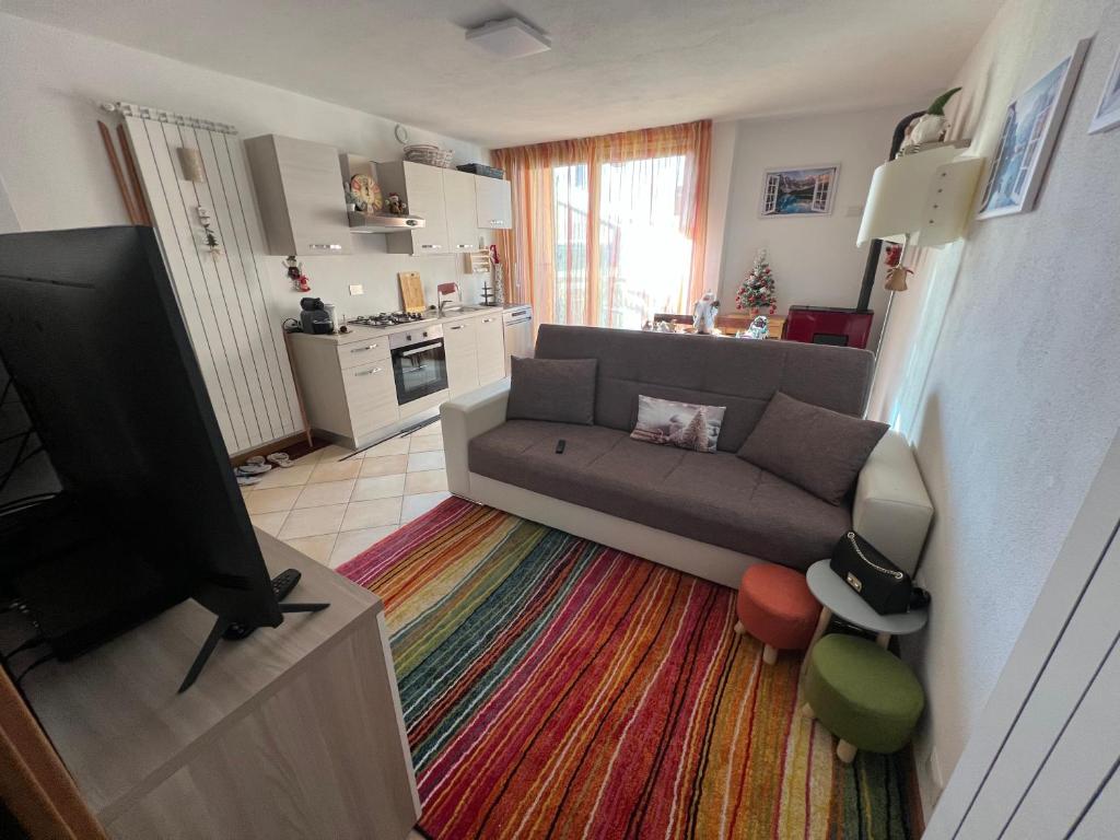 a living room with a couch and a flat screen tv at APPARTAMENTO PRIMOLO - CHIESA IN VALMALENCO in Chiesa in Valmalenco