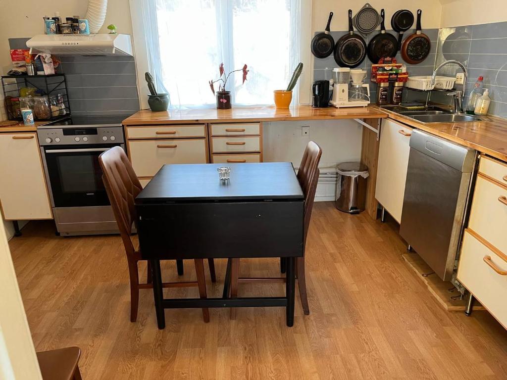 a kitchen with a black table and chairs in it at Dammyr, close to City with parking in Fredrikstad
