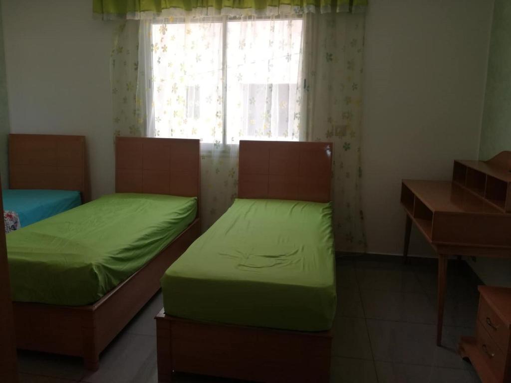 two beds in a room with a window at s 2 1 km from the beach mansoura kelibia in Kelibia