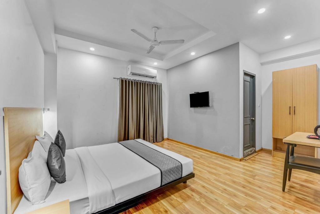 a bedroom with a large bed and a desk at Upar Hotels Nungambakkam Nearby US Consulate Apollo hospital Sankara Nethralaya in Chennai