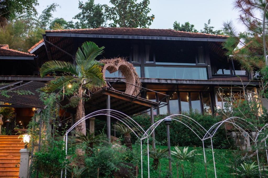 uma casa com uma escultura de um dragão à frente dela em U Maerim Chiangmai - อยู่แม่ริม เชียงใหม่ em Mae Rim