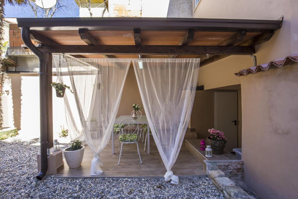 eine hölzerne Pergola mit einem Tisch auf der Terrasse in der Unterkunft Apartment with garden and free parking in Pula