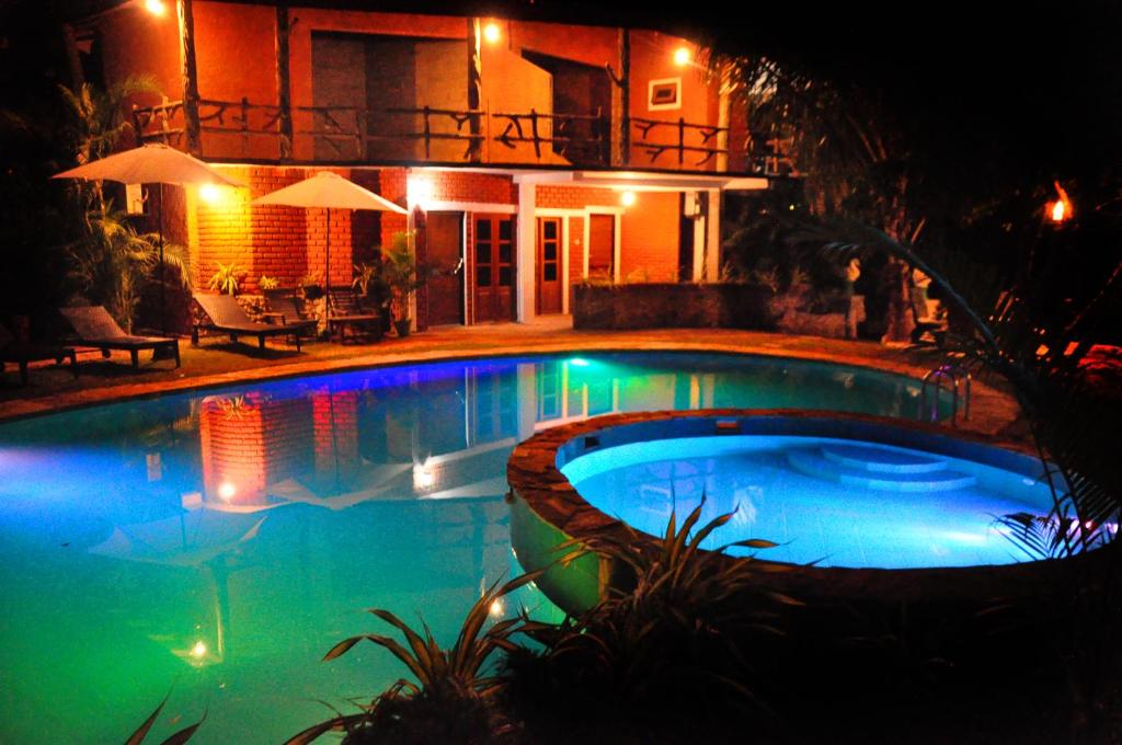 a swimming pool in front of a house at night at Sigiri Heritage Villa in Sigiriya