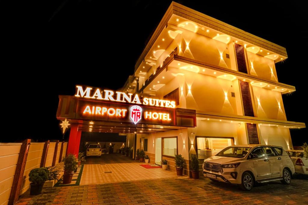 un hotel con un coche aparcado delante de él en MARINA SUITES AIRPORT HOTEL en Kochi