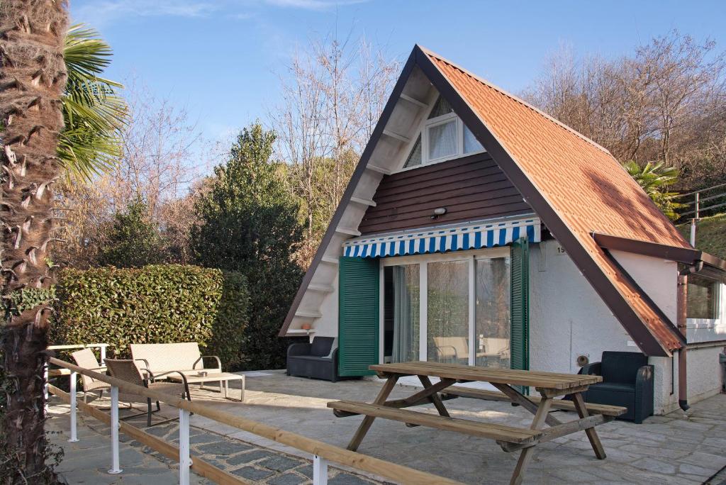 uma pequena casa com um telhado inclinado e uma mesa de piquenique em Casa Maro em Brezzo