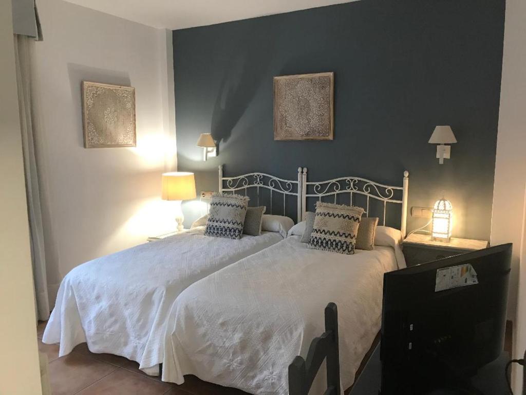 a bedroom with a large white bed with two pillows at Macavi in Rota