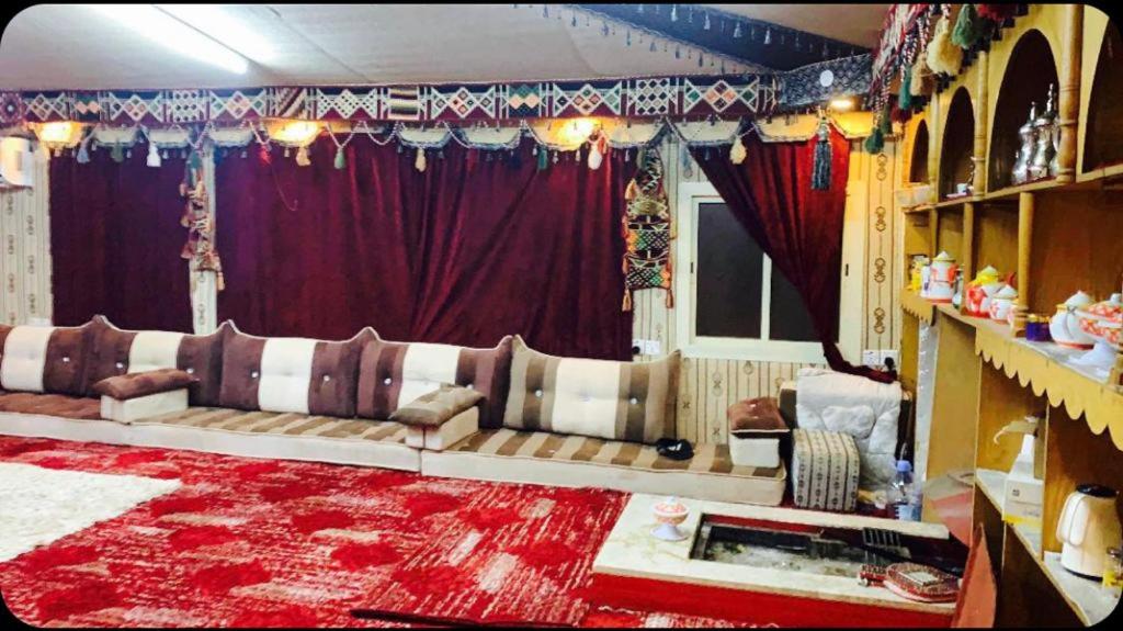 a living room with a couch and a red rug at استراحات ومخيم يمك دروبي in Madain Saleh