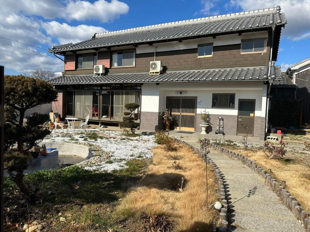 SUN庭園 في هيميجي: منزل أمامه حديقة