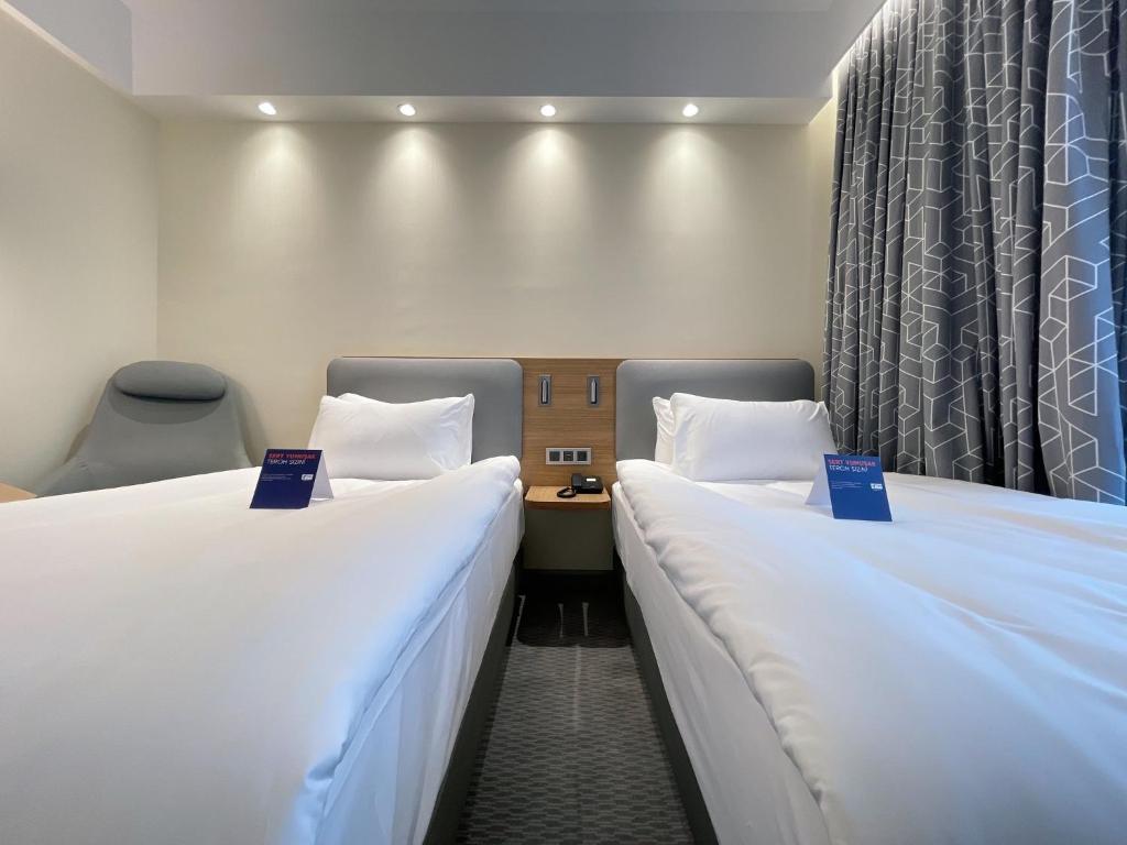 two beds in a hotel room with blue signs between them at Holiday Inn Express - Ankara - Airport by IHG in Ankara