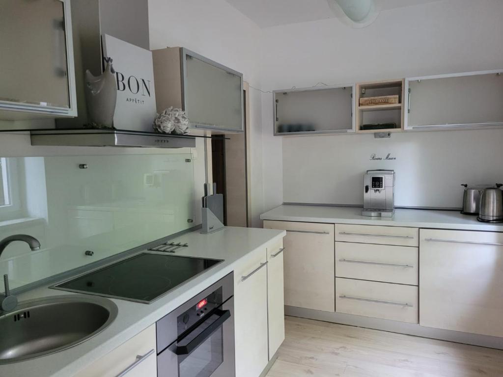 una cocina con armarios blancos y fregadero en Lux apartament Chodzież, ul Zwycięstwa 13, en Chodzież