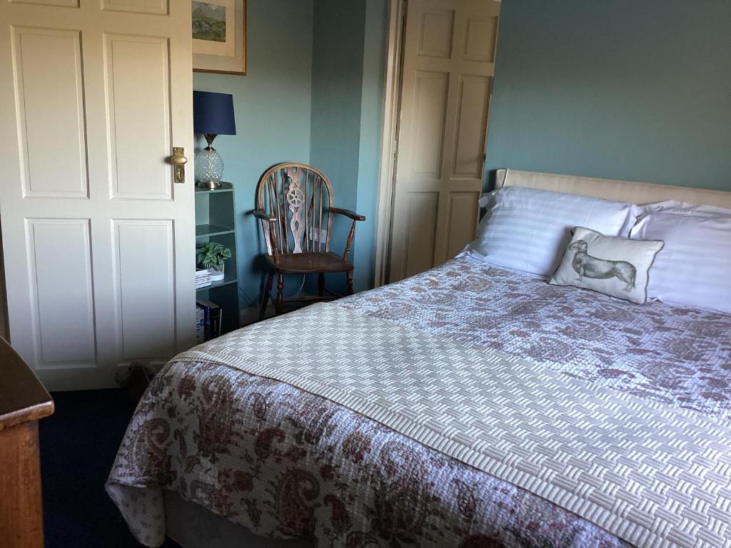 a bedroom with a bed and a chair at Valley View Farm, Bed and Breakfast in Batcombe