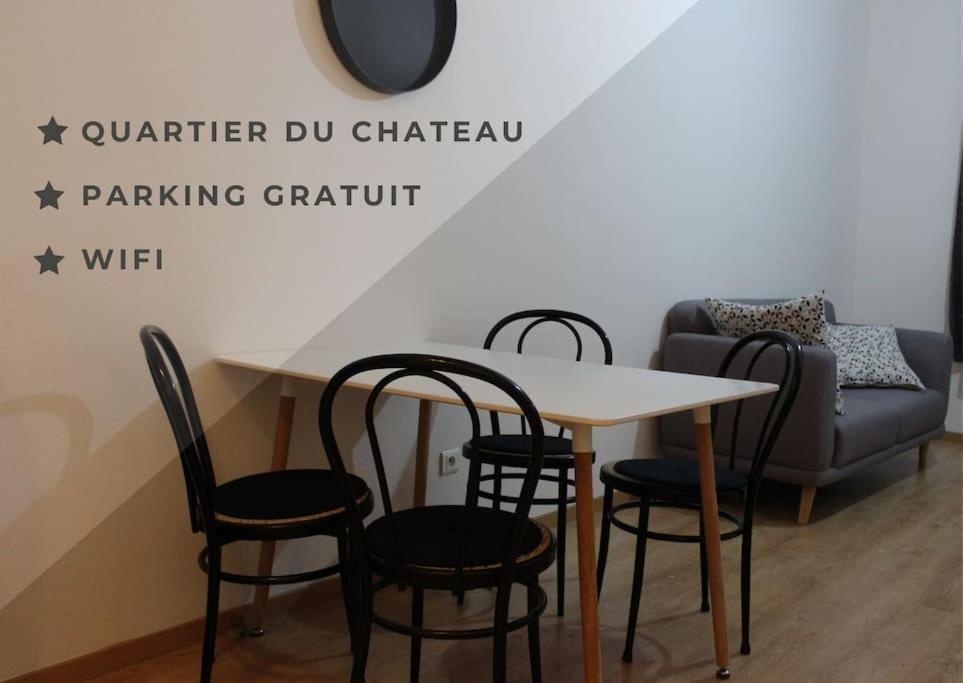 een tafel en stoelen en een bank in een kamer bij Spacieux F1 près du château in Lunéville