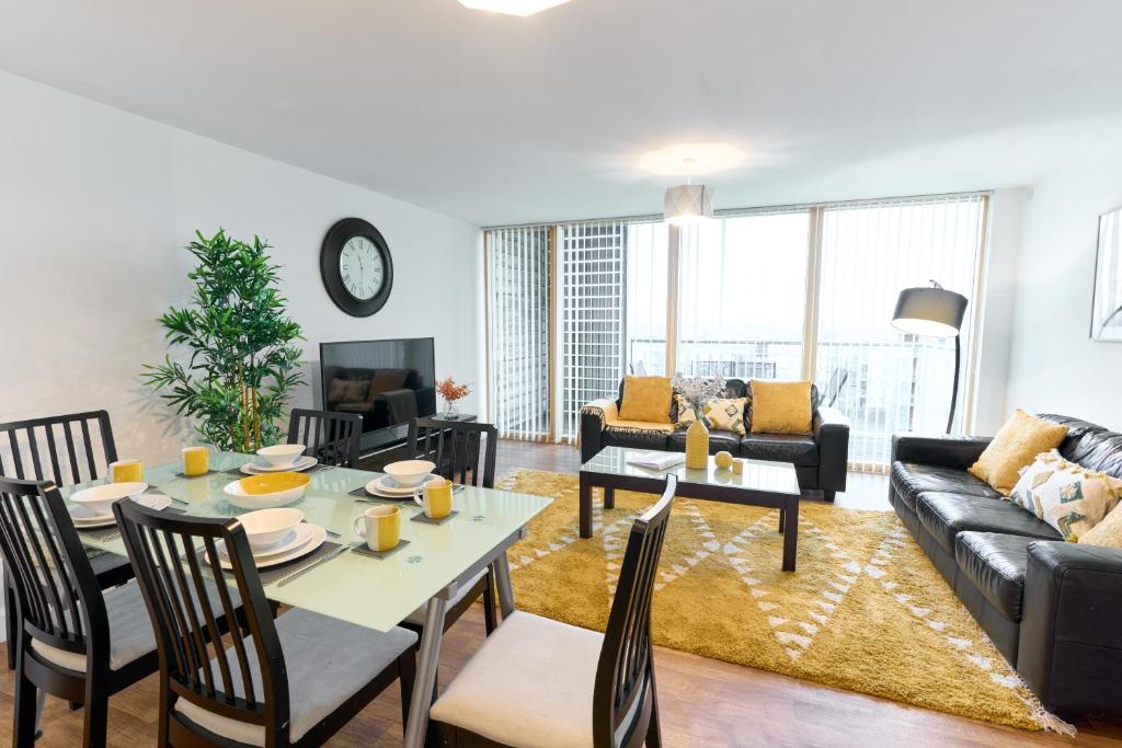 a living room with a table and a couch at ShortstayMK Vizion apartments, with free superfast wi-fi, parking, Sky sports and movies in Milton Keynes