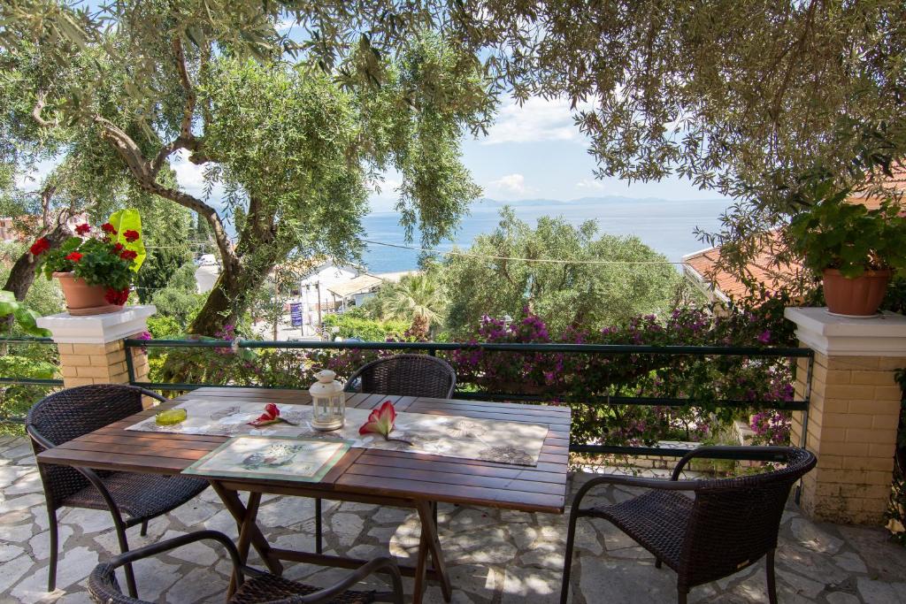 a table and chairs on a balcony with a view at Eleni's Apartments in Barbati