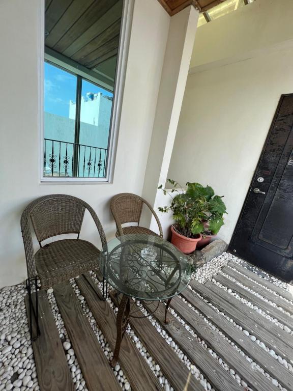 a glass table and two chairs on a porch at Ming Jun Homestay in Eluan