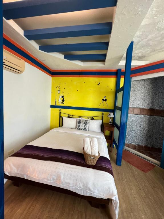 a bedroom with a bed with a yellow and blue ceiling at Ming Jun Homestay in Eluan