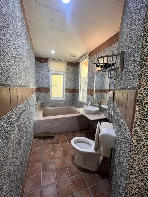 a bathroom with a tub and a toilet and a sink at Ming Jun Homestay in Eluan