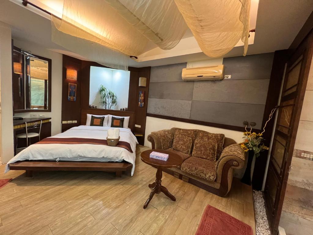 a bedroom with a bed and a couch at Ming Jun Homestay in Eluan