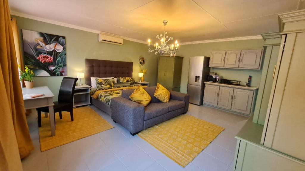 a living room with a couch and a kitchen at Arum Lily Guest Rooms in Pretoria