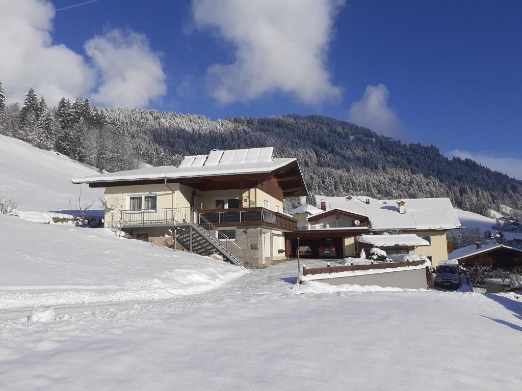 una casa en la nieve con un patio cubierto de nieve en Apartment Schilcher, en Oberau