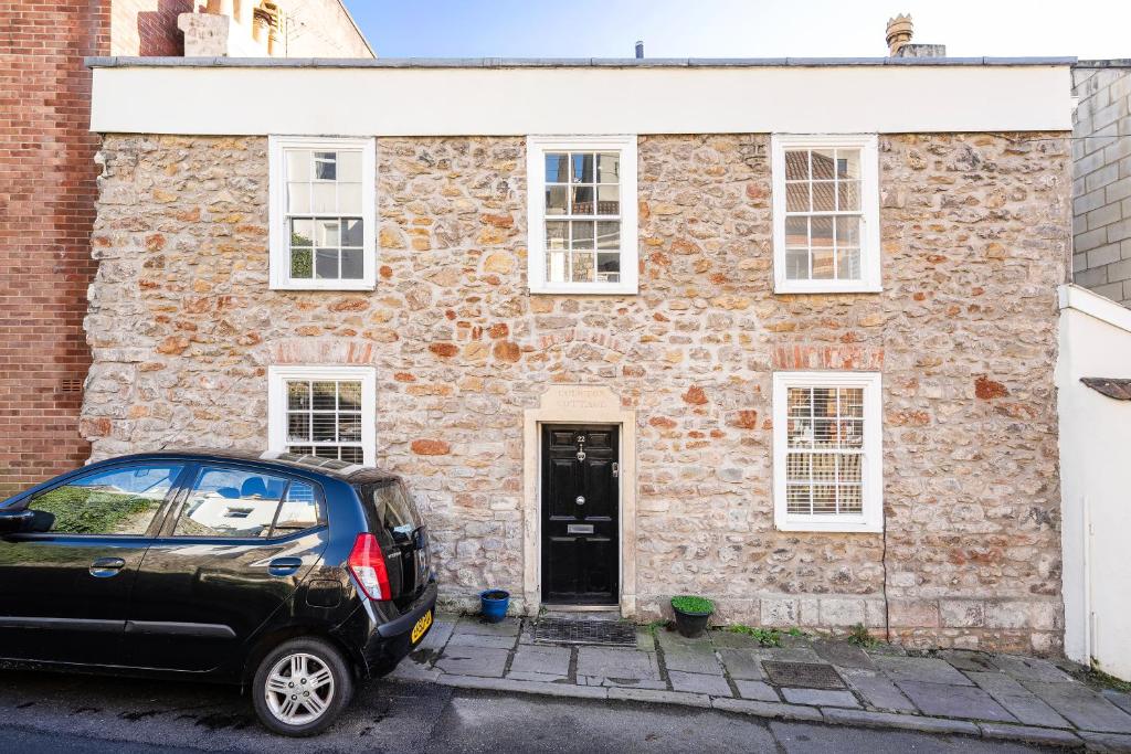 a car parked in front of a stone house at Fabulous 2 bedroom cottage in fantastic Clifton - Simply Check In in Bristol