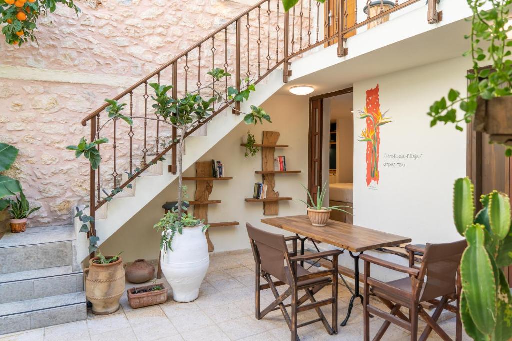 un patio con mesa, sillas y escaleras en Lemon Garden Residence, en Heraclión