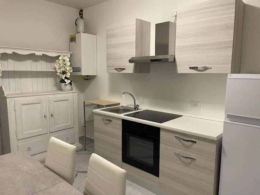 uma cozinha com um lavatório e um fogão forno superior em Casa Dea 3 em Seriate