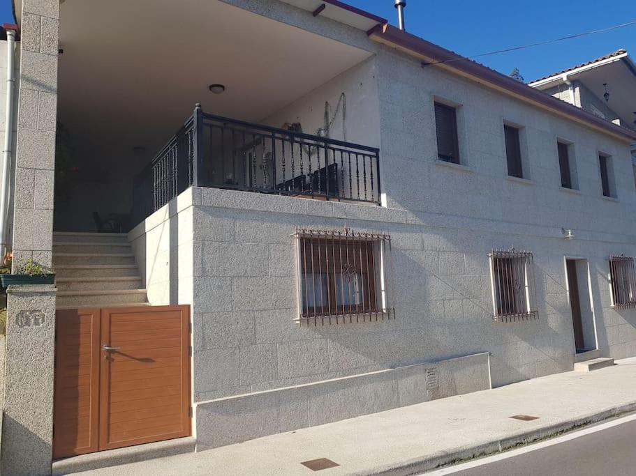 - Edificio con puerta de madera y balcón en Casa Saladina, en Pontevedra