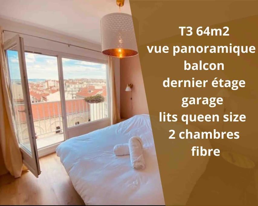 een slaapkamer met een bed en een groot raam bij T3 Hypercentre-dernier étage-Balcon-Garage-Queen beds-vue panoramique in Saint-Étienne
