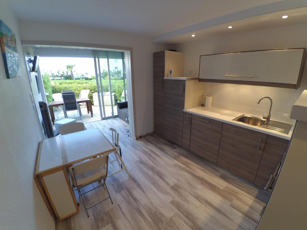 een keuken en eetkamer met een tafel en stoelen bij ABBAYE DU CAP Très joli T2 moderne proche port ABBAYE DU CAP Cap d'Agde in Cap d'Agde