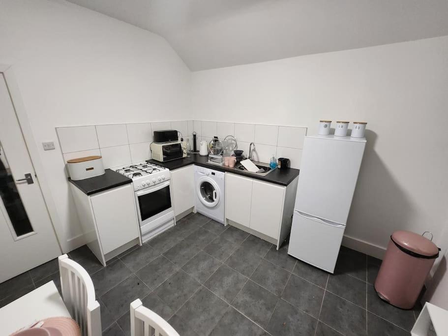 a small kitchen with a stove and a refrigerator at Nice cosy flat. Walking distance to city in Nottingham
