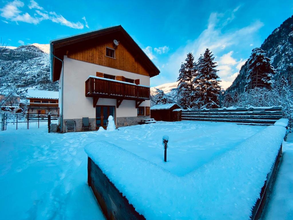 a house in the snow with mountains in the background at Chalet Les Ecrins in Vénosc