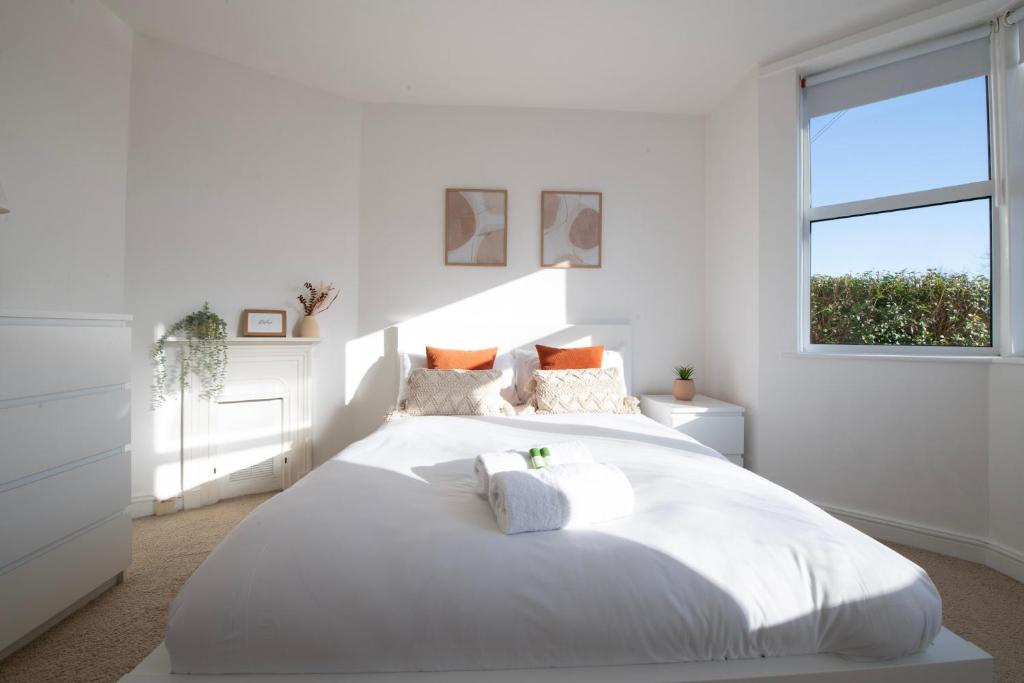 ein weißes Schlafzimmer mit einem großen weißen Bett mit zwei Kissen in der Unterkunft Hampton House - Sleeps 7 - Free Parking and WiFi in Bristol