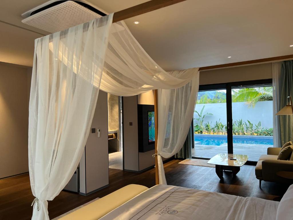 - une chambre avec un lit et une vue sur la piscine dans l'établissement Looma Private Pool Villas, à Pantai Cenang