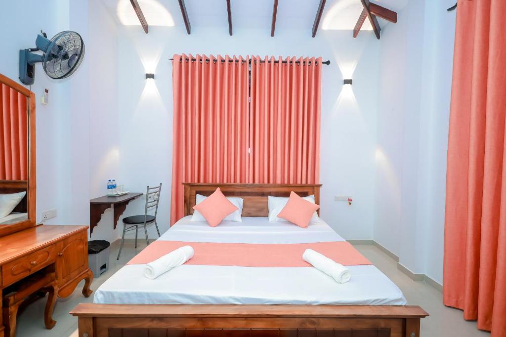 a bedroom with a bed and a desk and a table at Howick Residence in Katunayaka