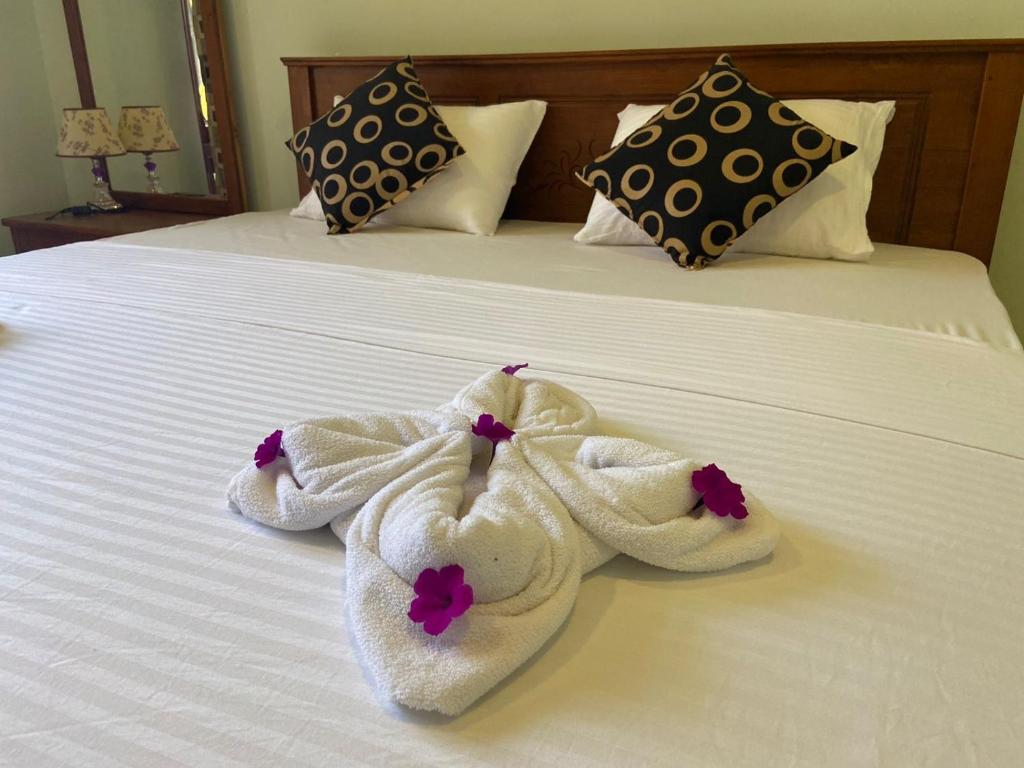 un par de toallas encima de una cama en Nirosha Guest House en Galle