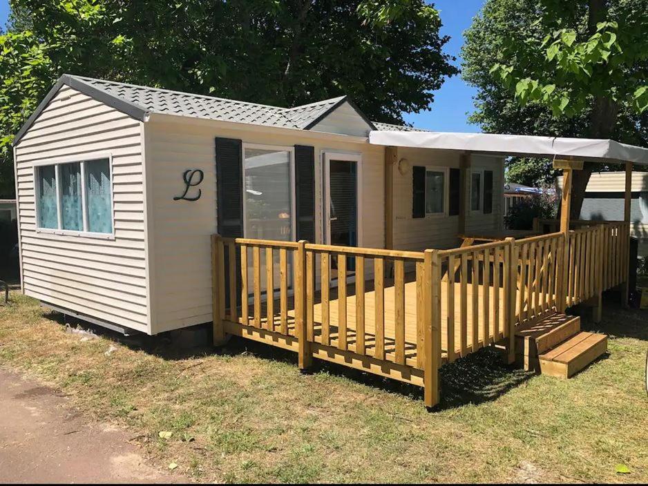 a small house with a porch and a deck at Mobilhome 4/6 personnes proche La Palmyre, Royan in Saint-Augustin